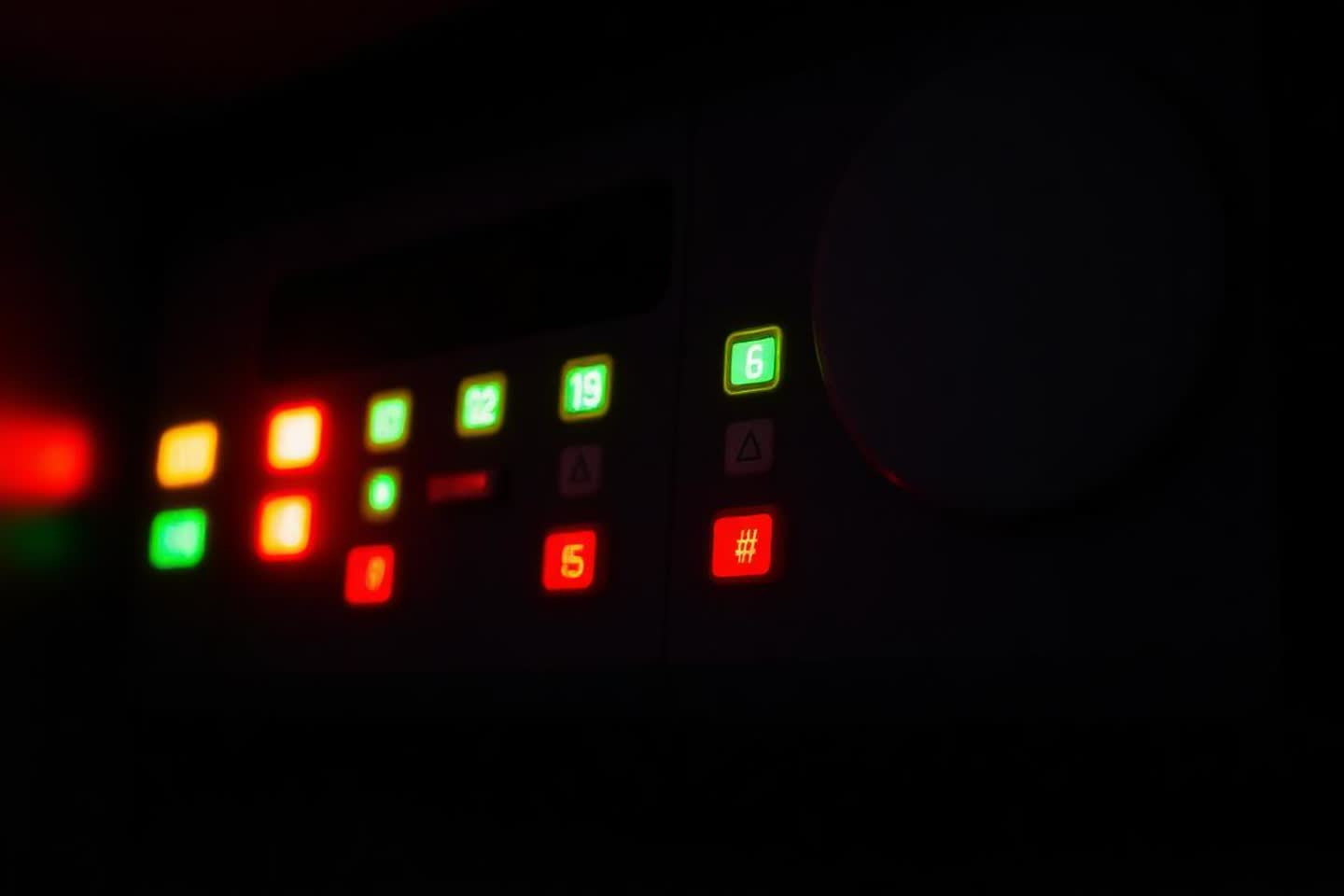 Wall-mounted fire alarm control panel with status indicator lights inside a commercial building